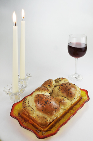 Shabbat Meal, Challah, Glass of Red Wine, Two Lit Candles on Whiteの写真素材
