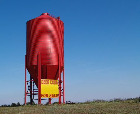 Small red grain silo used to sell corn for deer.   の写真素材