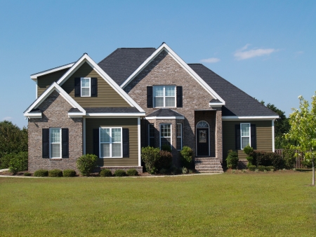 Two story brick and vinyl residential home with bay window.の写真素材
