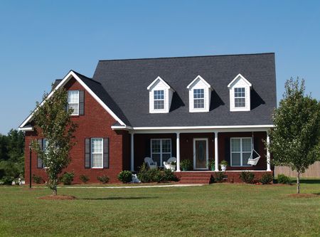 Two story brick residential home with porch swing.の写真素材