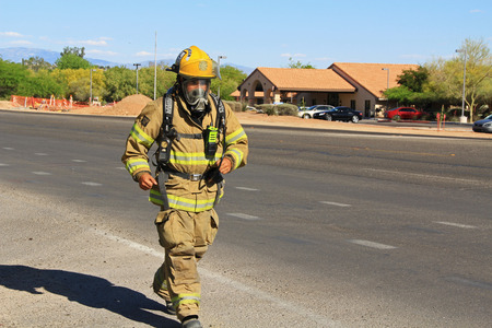 TUCSON, ARIZONA, USA --April 21, 2014   A Firefighter who is training by running alongside the road with his protective suit and air pack on in Arizona のeditorial素材