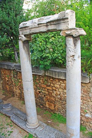 Looking down into an excavated area you will see an old historic marble column doorway located in downtown Athens, Greece.の写真素材
