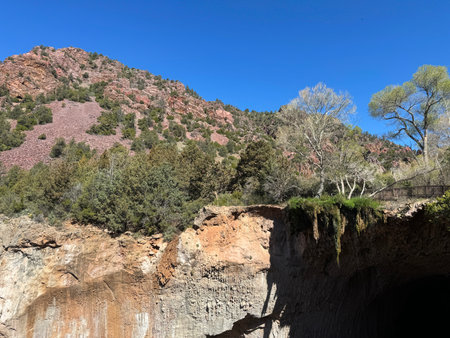 Springtime view of the red rocky mountain landscape in Tonto Natural Bridge State Park in Pine, Arizona with bright blue sky copy space in an area showing the foot bridge and the sの写真素材