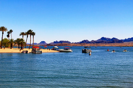 Boats on a beach on the Bridgewater Channel in Lake Havasu City, Arizona, USA on lake Havasu with blue sky copy space.の写真素材
