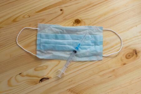 Medical protective mask and syringe on the tableの写真素材