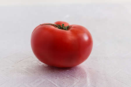 one tomato on a white tableclothの写真素材