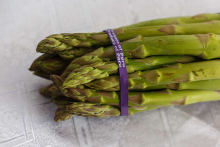 knitted bunch of asparagus on a white tableclothの写真素材