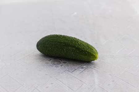 one cucumber on a white tableclothの写真素材