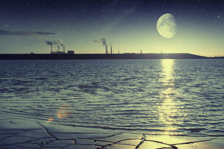 factory smoke from a pipe on a of lake at sunset. の写真素材