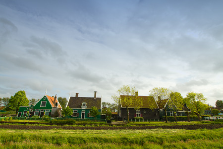 rural dutch scenery of small old houses and canal in Zaanse, Netherlandsの写真素材