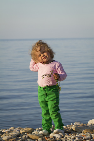 Girl in the autumn at the sea . standing against the evening seaの写真素材