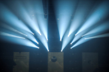 stage before the concert shines the beams of searchlights