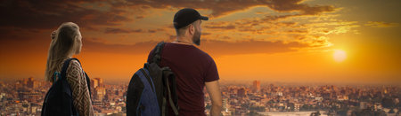 girl with a male traveler stands with backpacks against the backdrop of Cairo, Egypt.