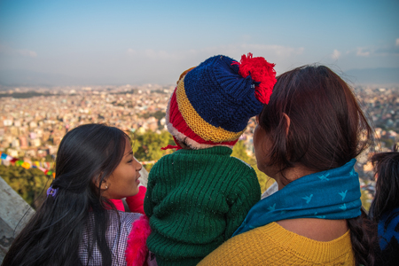 KATMANDU, NEPAL - DECEMBER 19, 2017: A woman with two children looks at the Kathmandu valley from the top, Kathmanduのeditorial素材