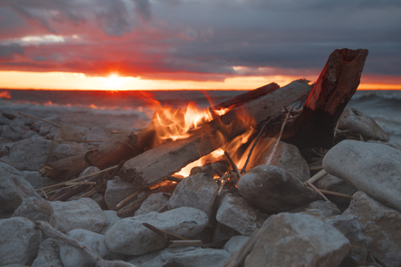 A bonfire burns in a camping in a forest by the sea.の写真素材