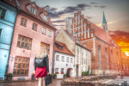a woman walks down the street of Riga.の写真素材