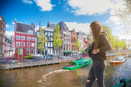 The girl listens to music and walks around Amsterdamの写真素材