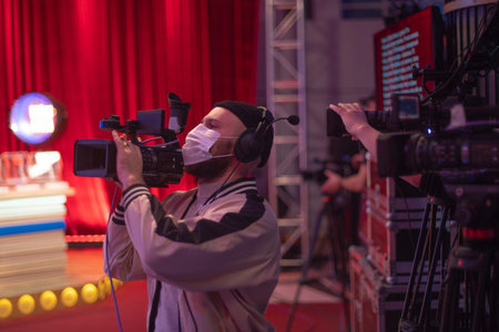 masked cameraman is filming a television show in the studio. TV