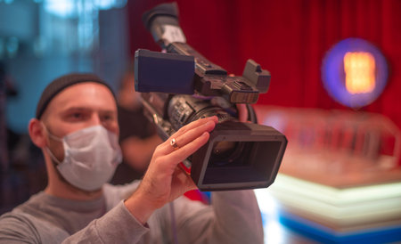 masked cameraman is filming a television show in the studio. TV