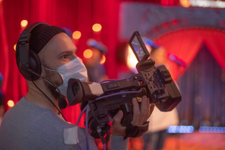masked cameraman is filming a television show in the studio. TV