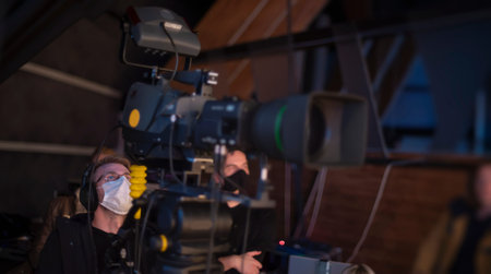 masked cameraman is filming a television show in the studio. TV