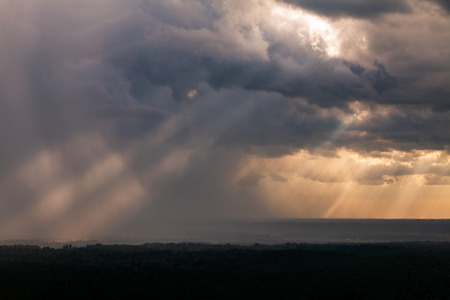 Sun rays breaking through clouds on a stormy cloudy dayの写真素材