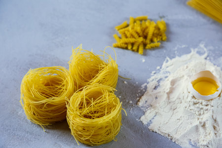 ingredients for homemade pasta. Food background: macaroni, spagetti, egg, flourの写真素材