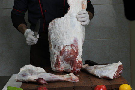 A butcher wrapping a piece of pork meat on a counterの写真素材