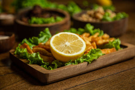 Food for a holiday for a large company. hot meat snacks for beer served on wooden dish board top view, flat layの写真素材