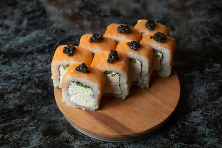 Traditional delicious fresh sushi roll set on a black background with reflection. Sushi roll with rice, red fish, salmon. Sushi menu. Japanese kitchen, restaurant. Seafood, asian foodの写真素材