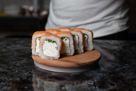 Traditional delicious fresh sushi roll set on a black background with reflection. Sushi roll with rice, red fish, salmon. Sushi menu. Japanese kitchen, restaurant. Seafood, asian foodの写真素材