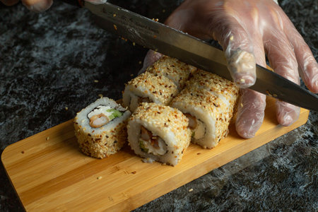 Traditional delicious fresh sushi roll set on a black background with reflection. Sushi roll with rice, cream cheese, avocado, salmon, sesame. Philadelphia. Sushi menu. Japanese kitchen, restaurant.の写真素材