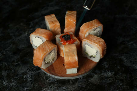 Traditional delicious fresh sushi roll set on a black background with reflection. Sushi roll with rice, red fish, salmon. Sushi menu. Japanese kitchen, restaurant. Seafood, asian foodの写真素材