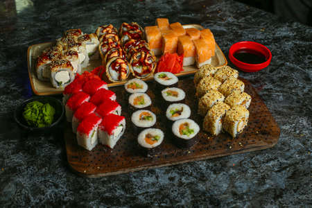 Traditional delicious fresh sushi roll set on a black background with reflection. Sushi roll with rice, red fish, salmon. Sushi menu. Japanese kitchen, restaurant. Seafood, asian foodの写真素材