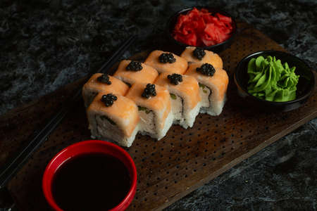 Traditional delicious fresh sushi roll set on a black background with reflection. Sushi roll with rice, red fish, salmon. Sushi menu. Japanese kitchen, restaurant. Seafood, asian foodの写真素材