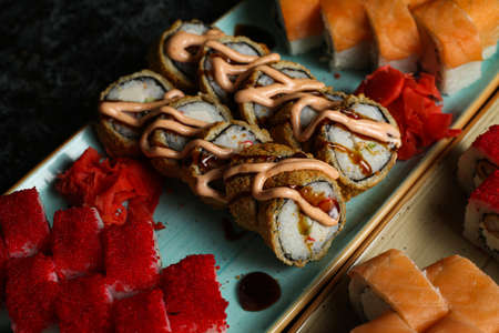 Traditional delicious fresh sushi roll set on a black background with reflection. Sushi roll with rice, red fish, salmon. Sushi menu. Japanese kitchen, restaurant. Seafood, asian foodの写真素材