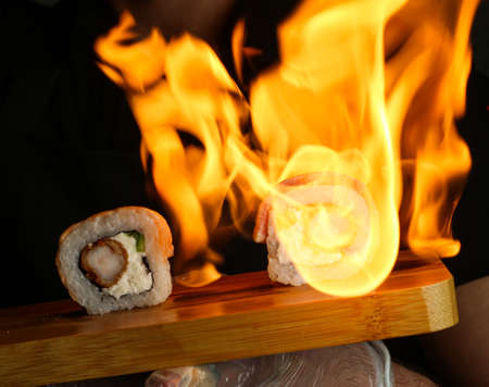 the cook prepares sushi with the help of fireの写真素材