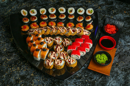 Traditional delicious fresh sushi roll set on a black background with reflection. Sushi roll with rice, red fish, salmon. Sushi menu. Japanese kitchen, restaurant. Seafood, asian foodの写真素材