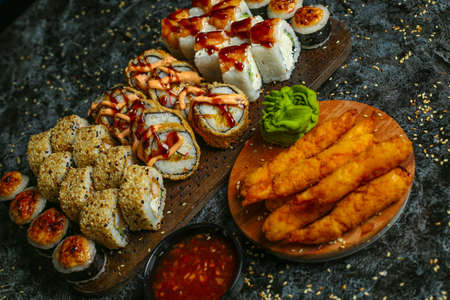 Traditional delicious fresh sushi roll set on a black background with reflection. Sushi roll with rice, red fish, salmon. Sushi menu. Japanese kitchen, restaurant. Seafood, asian foodの写真素材