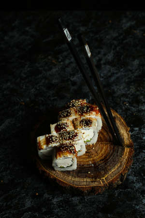 Traditional delicious fresh sushi roll set on a black background with reflection. Sushi roll with rice, red fish, salmon. Sushi menu. Japanese kitchen, restaurant. Seafood, asian foodの写真素材