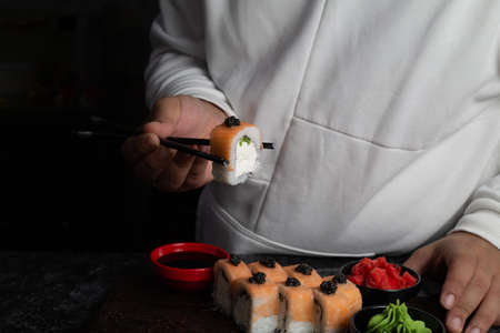 Traditional delicious fresh sushi roll set on a black background with reflection. Sushi roll with rice, red fish, salmon. Sushi menu. Japanese kitchen, restaurant. Seafood, asian foodの写真素材