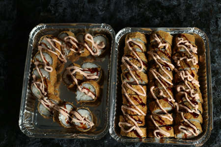 Hot fried Sushi Roll with salmon, avocado and cheese. Sushi menu. Japanese food.の写真素材