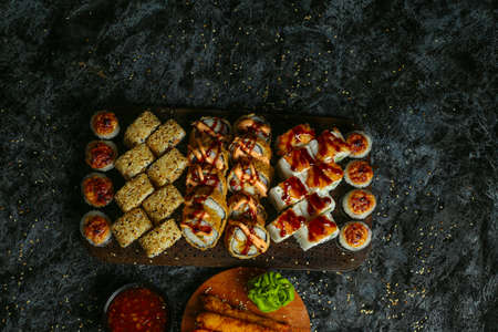 Traditional delicious fresh sushi roll set on a black background with reflection. Sushi roll with rice, red fish, salmon. Sushi menu. Japanese kitchen, restaurant. Seafood, asian foodの写真素材