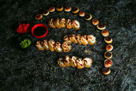 Traditional delicious fresh sushi roll set on a black background with reflection. Sushi roll with rice, red fish, salmon. Sushi menu. Japanese kitchen, restaurant. Seafood, asian foodの写真素材