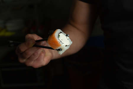 Traditional delicious fresh sushi roll set on a black background with reflection. Sushi roll with...