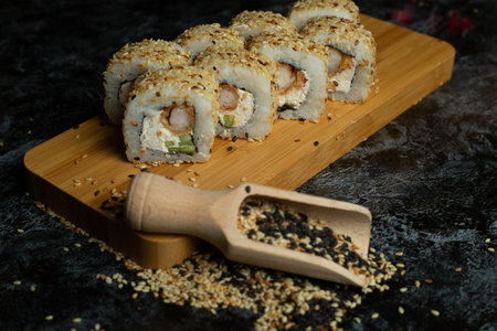 Traditional delicious fresh sushi roll set on a black background with reflection. Sushi roll with rice, cream cheese, avocado, salmon, sesame. Philadelphia. Sushi menu. Japanese kitchen, restaurant.の写真素材
