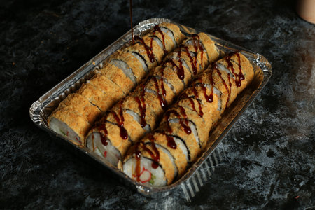 Hot fried Sushi Roll with salmon, avocado and cheese. Sushi menu. Japanese food.の写真素材