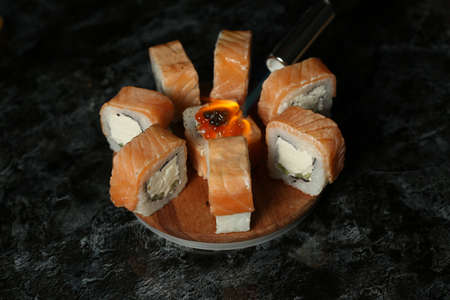 Traditional delicious fresh sushi roll set on a black background with reflection. Sushi roll with rice, red fish, salmon. Sushi menu. Japanese kitchen, restaurant. Seafood, asian foodの写真素材