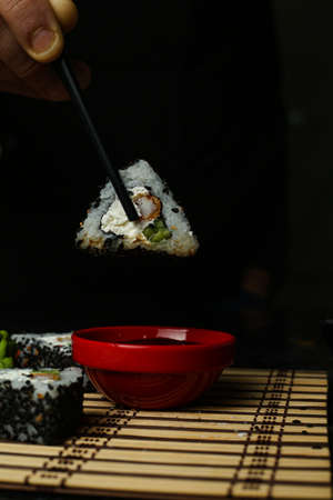 Traditional delicious fresh sushi roll set on a black background with reflection. Sushi roll with rice, red fish, salmon. Sushi menu. Japanese kitchen, restaurant. Seafood, asian foodの写真素材
