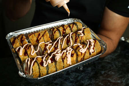 Hot fried Sushi Roll with salmon, avocado and cheese. Sushi menu. Japanese food.の写真素材